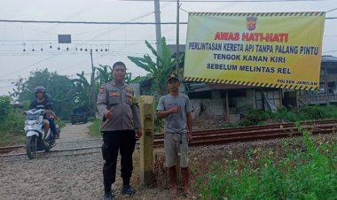 Bhabikamtibmas Desa Cemplang Pasang Spanduk Diperlintasan Kereta Listrik